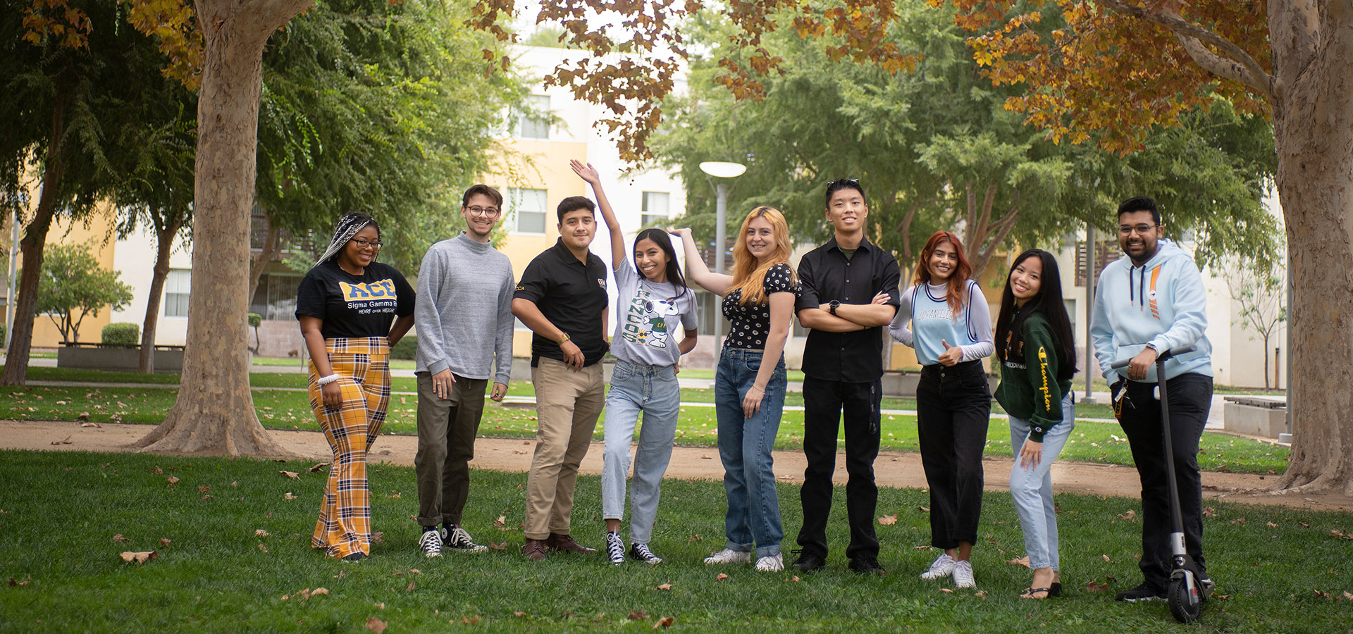 A group of students pose for a photo on grass.