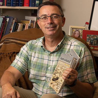 Liam Corley holding his book Unwound