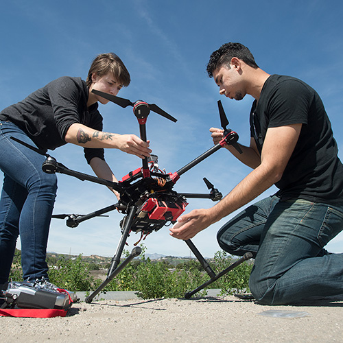 Two students work on a drone at Spadra Farms.
